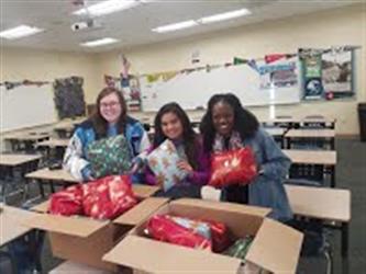 AVID student wrapping gifts for the AVID adopted family