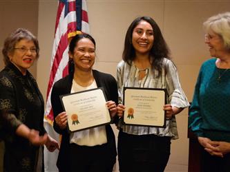 Scholarship recipients holding up framed certificates